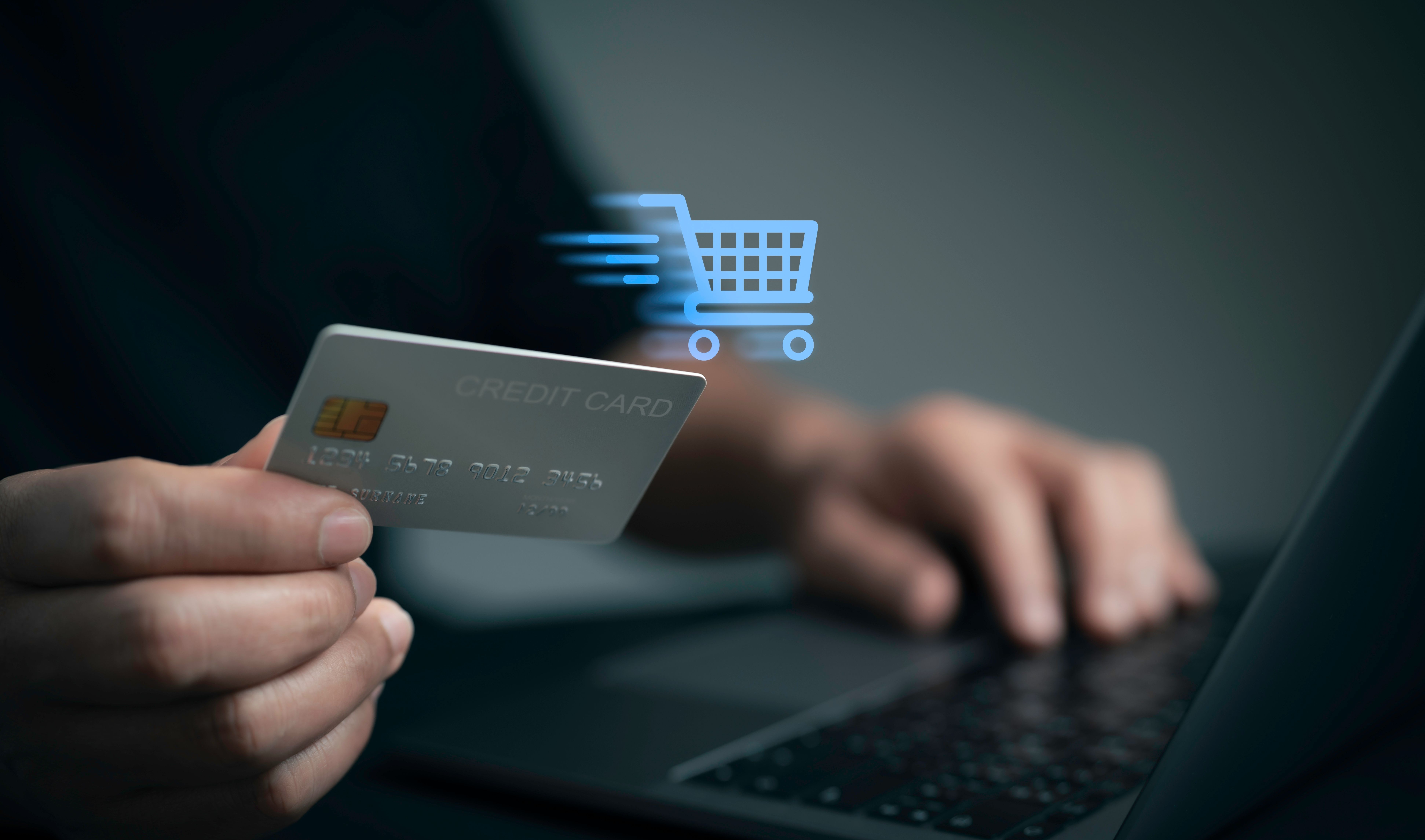 Man typing credit card details into a laptop