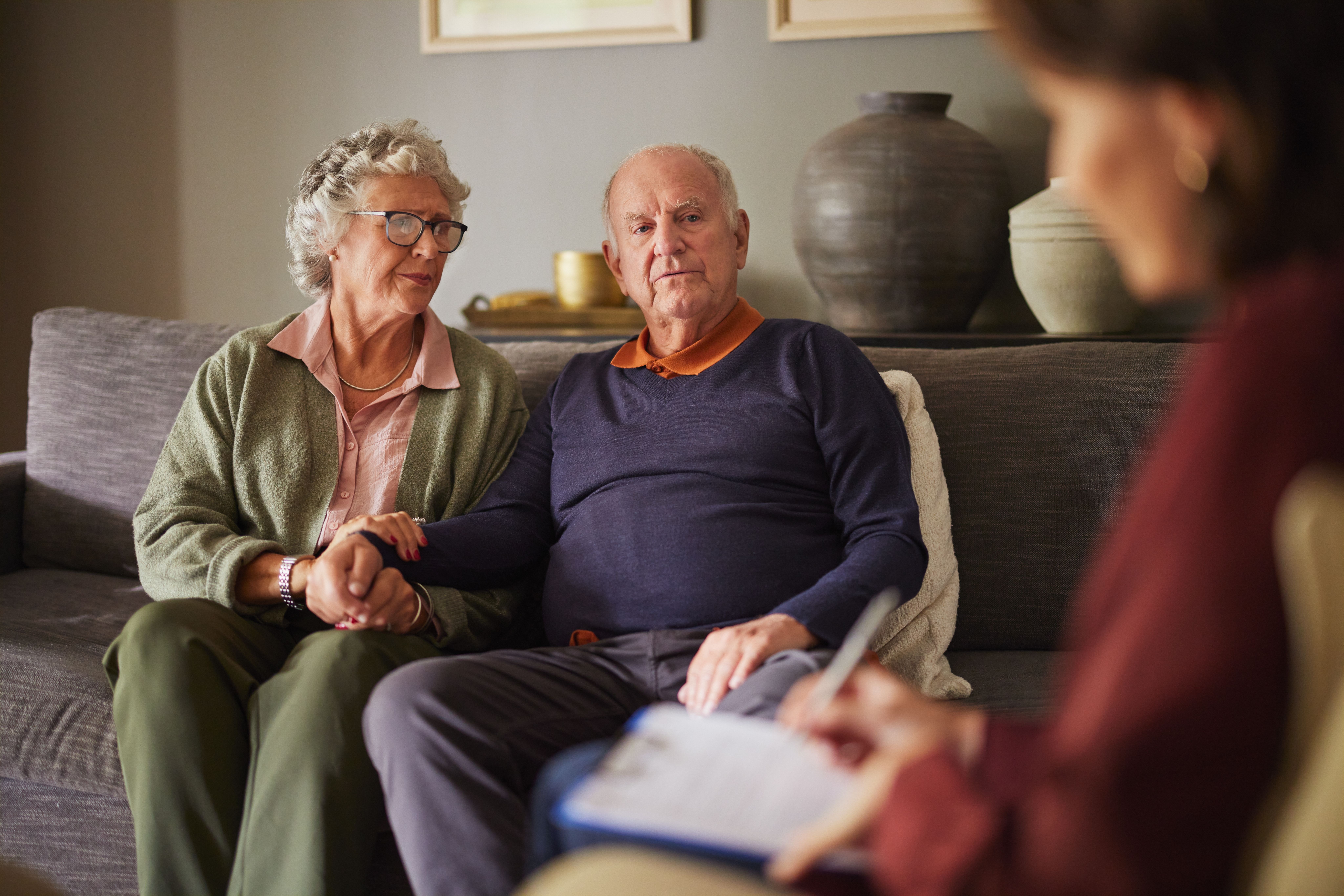 Elderly couple sat on a sofa with victim support work