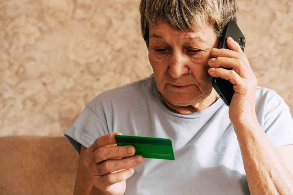 A naive elderly woman gives her bank card details to telephone scammers